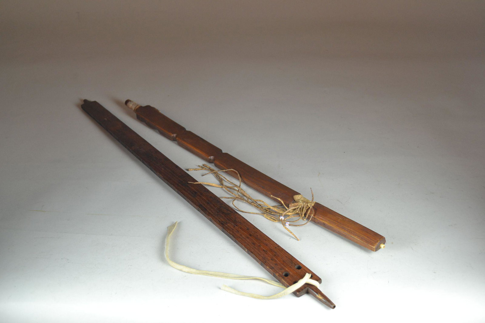 Pair of Wooden Pipe Stems: one has rawhide tassels, minor wear from use. Longest 28"