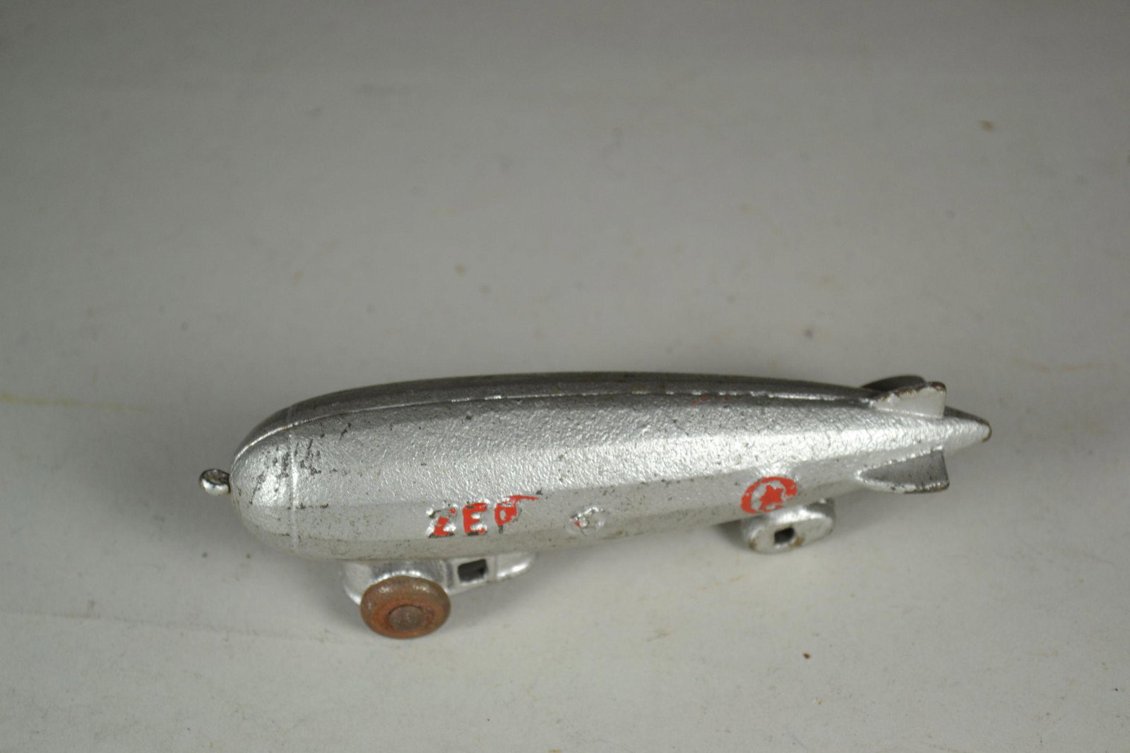 Zeppelin Cast Iron Pull Toy: marked ZEP on each side in red. Lite wear and has rust on wheels. 5" long