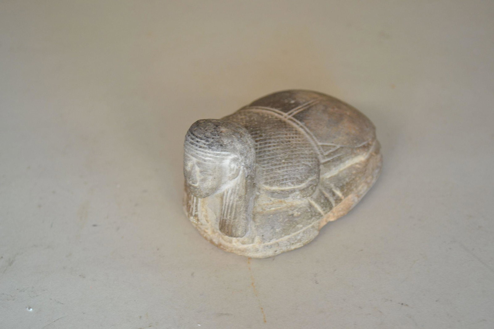 Rare Egyptian Scarab Seal: with human face. Has full inscription on bottom that is usually for a rulers anniversary. Heavy wear on one end of hieroglyphics. Multiple edge chips and other spots of wear. 2" h x 3 1/2" long