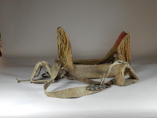 Rare 1870-80s Shoshone Hide over Wood Frame Female: pigment painted horns, leather tassels with orange ocre pigment. Has hide covered stirrups, everything is sewn with sinew. Belly strap is still attached. Stirrups are repaired with leather hanging str