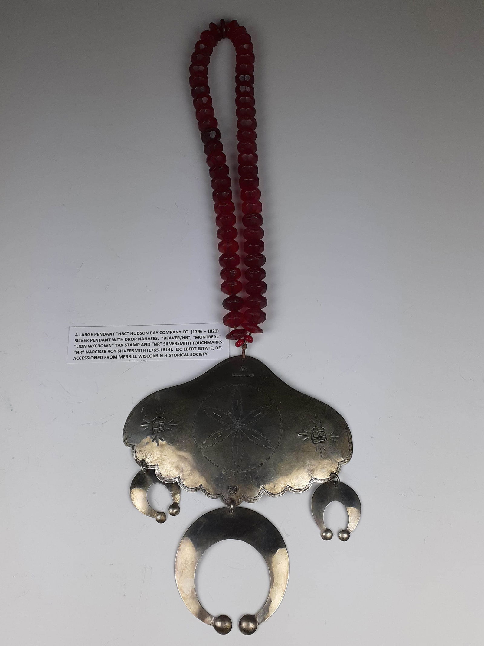 Hudson Bay Co Trade Gorget: with red glass bead necklace, NR Nar Cisse Roy 1765-1814 hallmark with HB and lion hallmarks. Minor wear, ex Ebert Estate. Deaccession from Merrill WI Historical Society. Beads show moderate wear, 18"