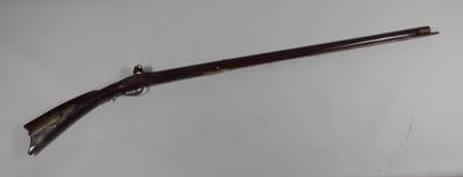 Full Stock Pennsylvania Flintlock Rifle: in approximately 50 caliber. Goulcher signed lock. Top flat has initials L.B. brass patchbox, nickel silver moon on cheek piece. Single trigger, brown grey gun with pitting throughout. Stock is very g