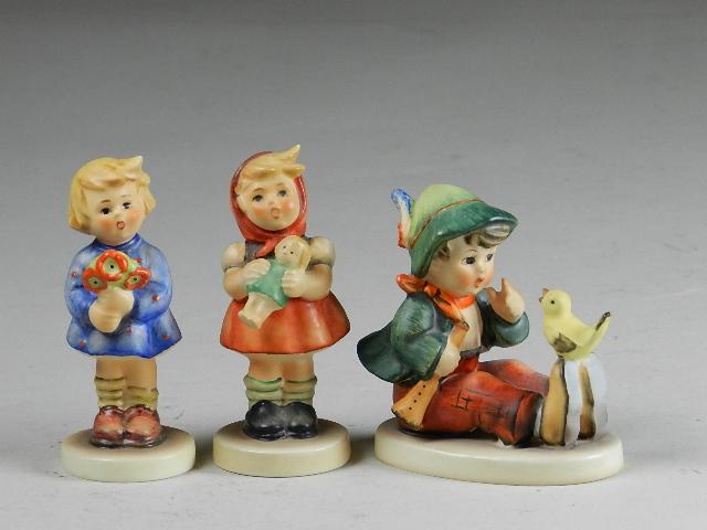 3 Goebel Hummels: singing lesson, girl with doll, and girl with flowers. Trademarks 3, 5 and 6, excellent condition, tallest 3 1/2"
