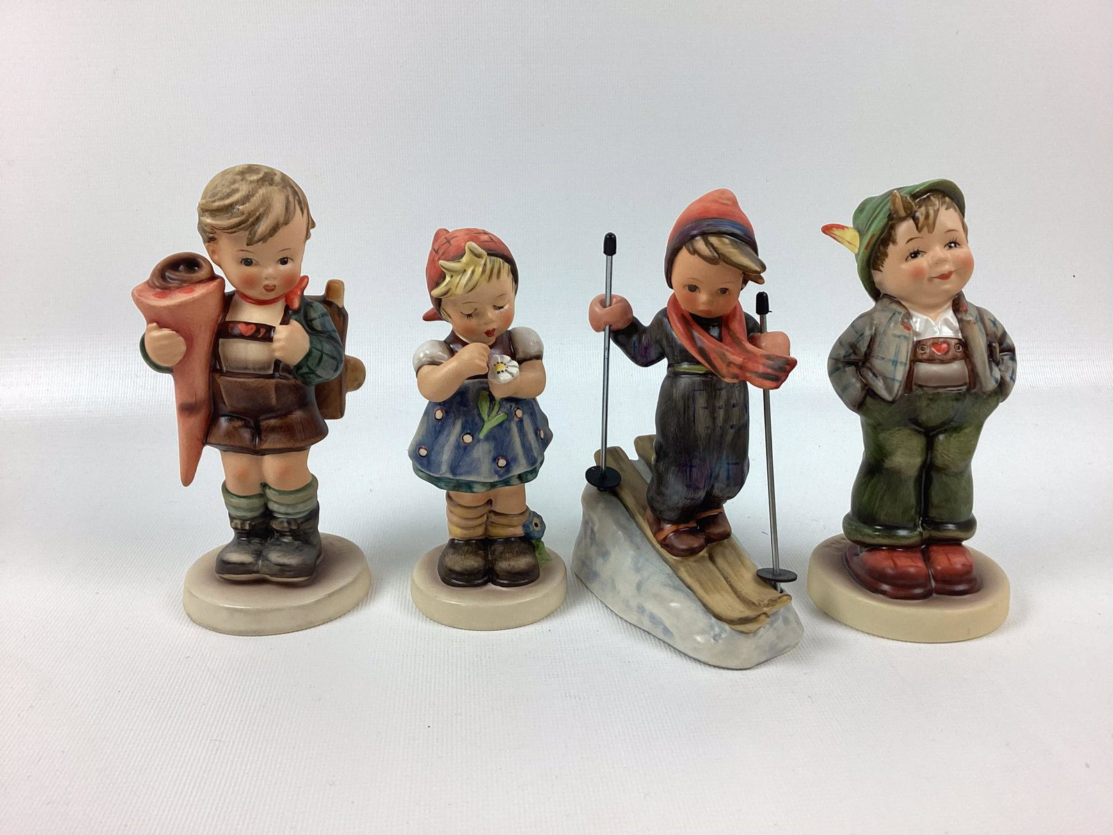 4 Goebel Hummels: Hello World, Skier, Daises Don?t Tell, Little Scholar. Trademark 6. Minor wear. Tallest 5 3/4".