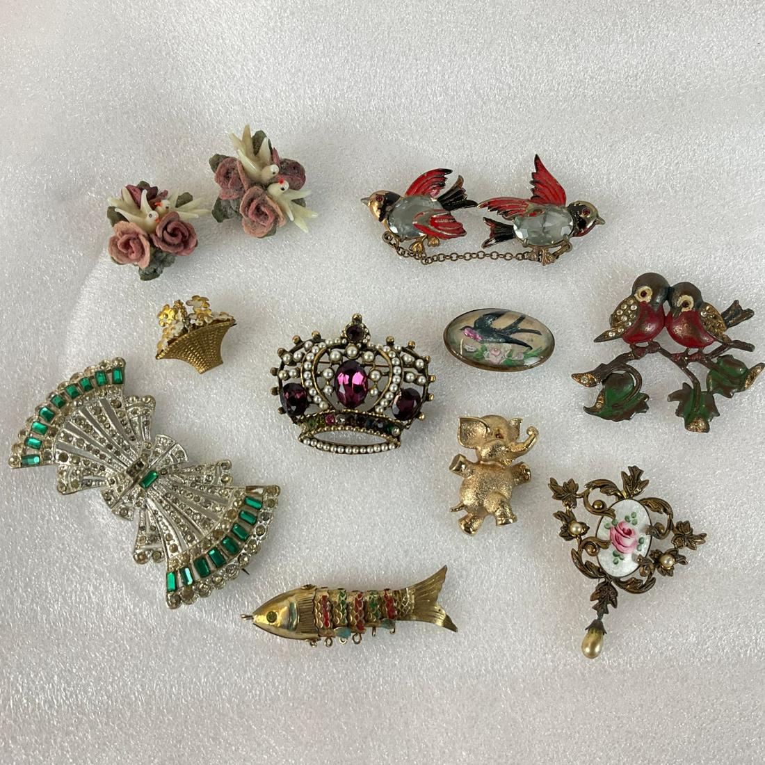 Costume Jewelry: J.J. elephant pin, Victorian intaglio swallow brooch, glass birds on flowers ( possibly originally buttons ), bid brooch missing stem hardware and bird sweater pin-all with paint loss, and more. Fair 