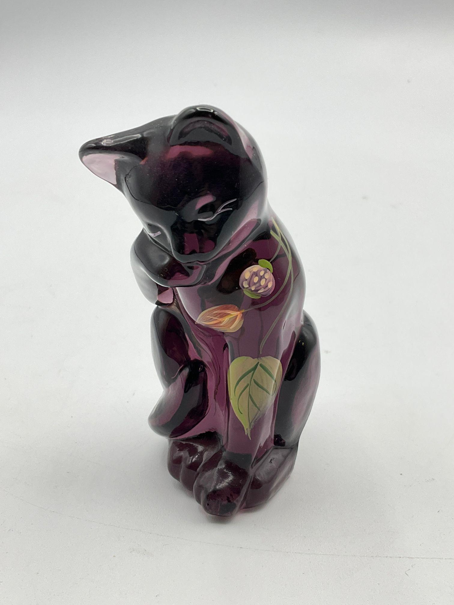 Fenton Grooming Cat Figurine: In aubergine. Hand painted, signed under sticker. With foil sticker. Good condition. 4 " tall.