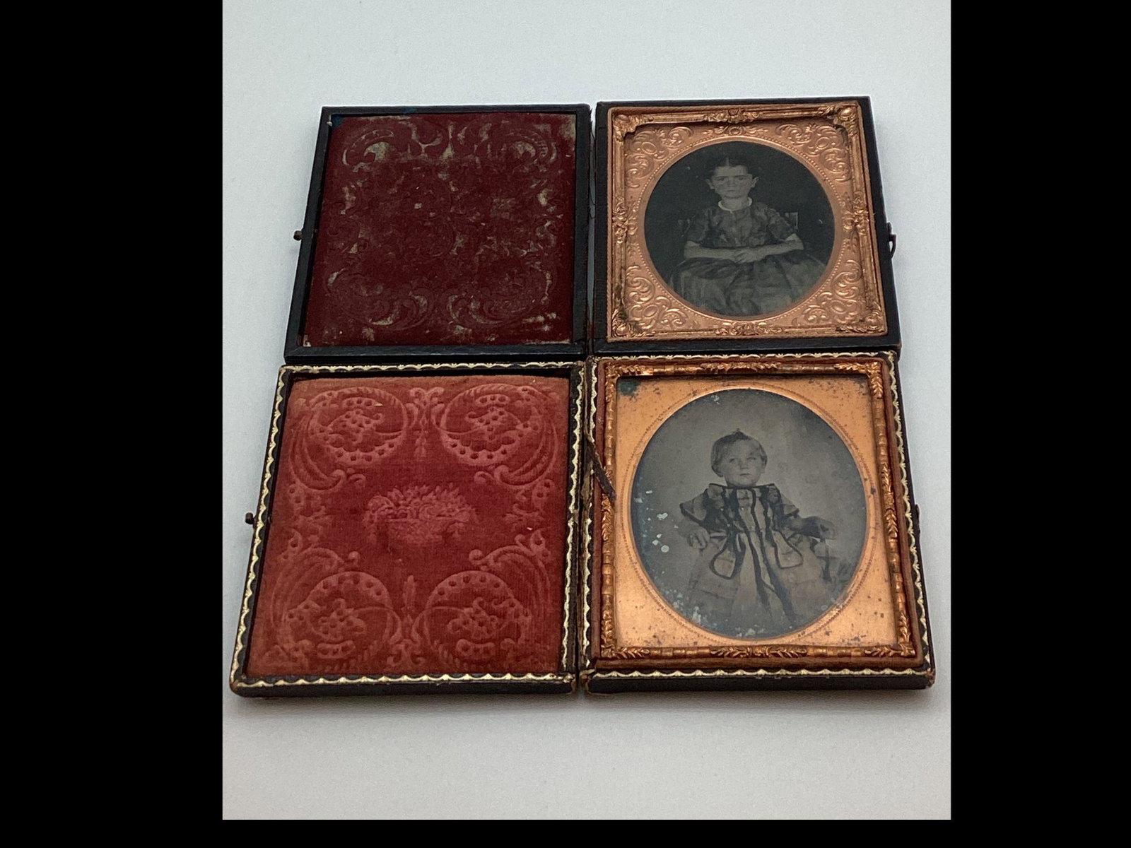 Two 1/6th Plate Ruby Ambrotypes of Children Circa 1860: Cases are split and show heavy wear. One shows some spotting. Cheeks are tinted.