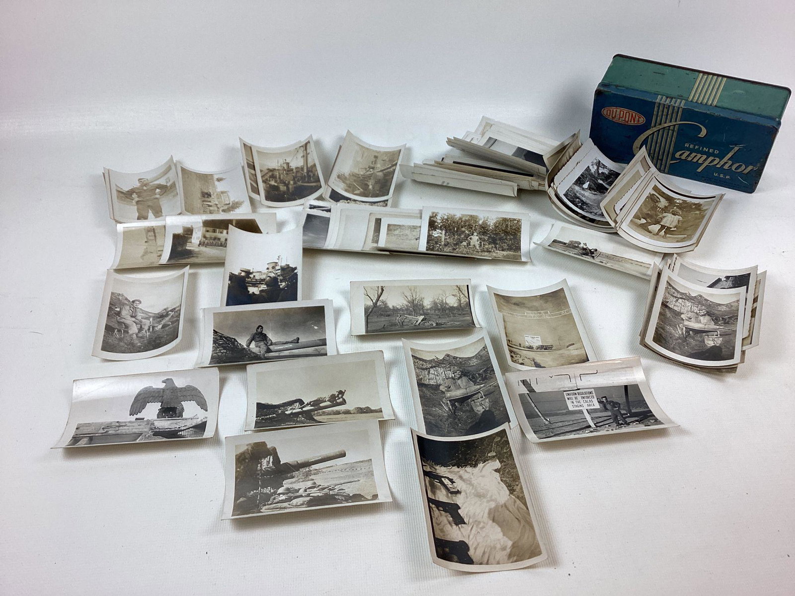 Large Lot of WWII American GI Photographs: Includes a shot of a large German building eagle, Calas staging area, artillery, ships, etc. one shows a Model 1911 Colt pistol with the plastic grips with picture underneath and two captured German p