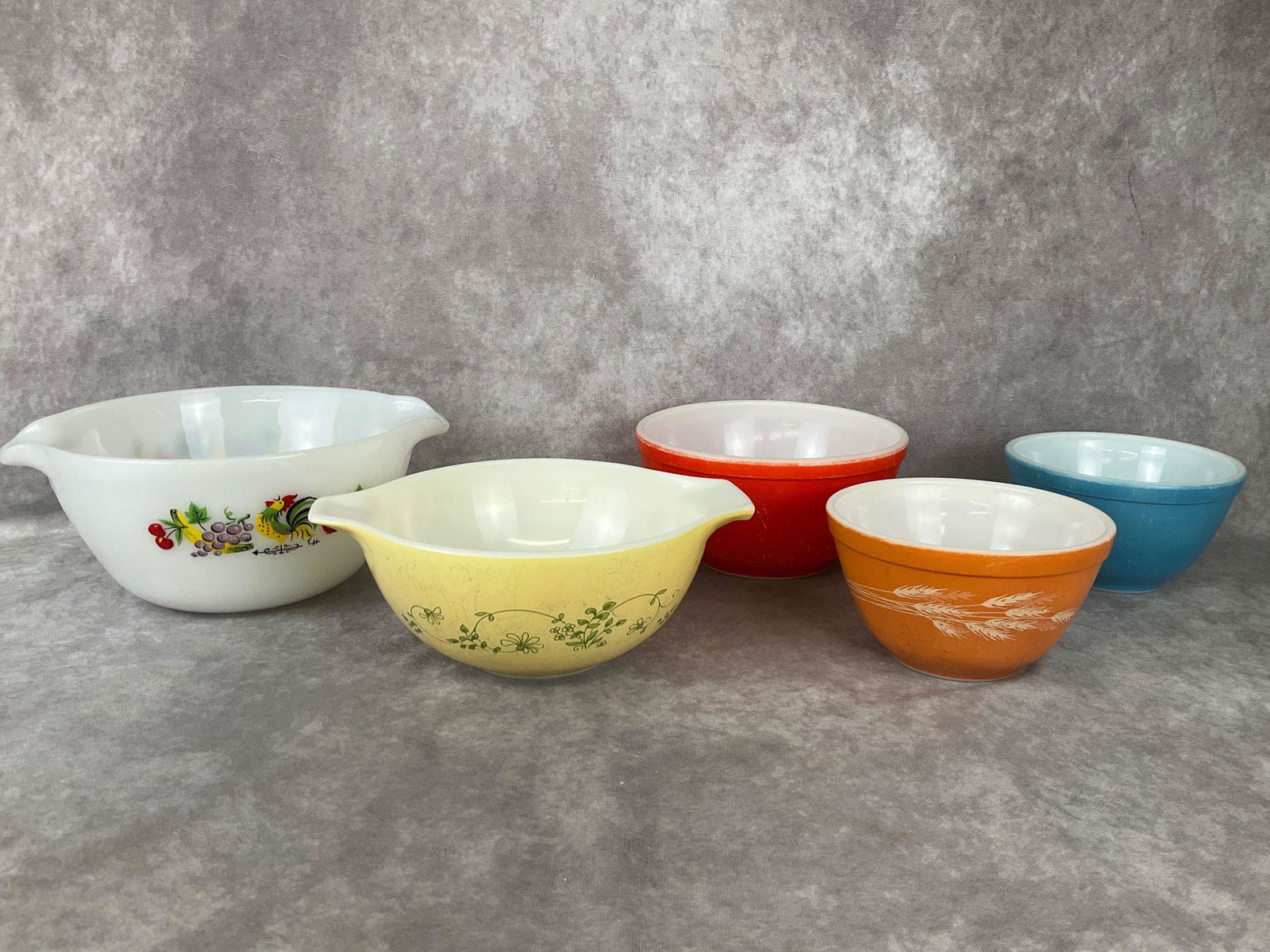 Pyrex & Fire King Bowls: Fire King bowl with fruits, vegetables, and rooster. 10 inches wide, good condition. All four of the Pyrex bowls show a fair amount of wear with scratches and marks.