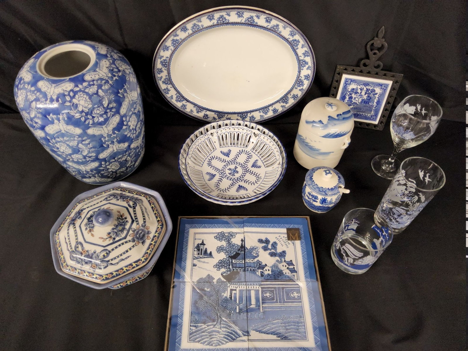 Group of Blue and White Dishes: 12 pieces. Includes oval platter, trivet , covered bowl, glasses, napkins. Some Canton and Blue Willow. Jar is 11 inches. Good condition.