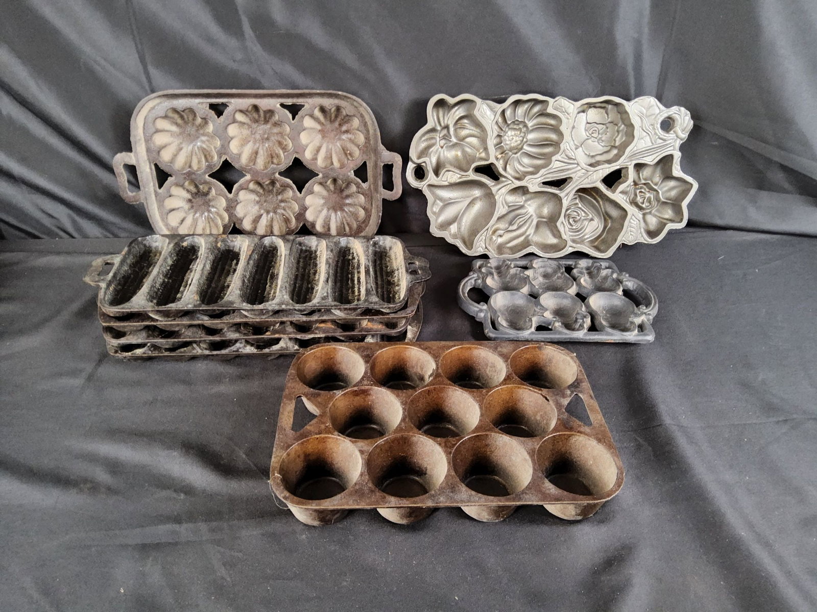 Large Group of Cast Iron Cornbread and Muffin Molds: Eight vintage and contemporary cast iron molds in various stages of wear as seen in photos. One is marked Wagner Junior and one is marked John Wright.
