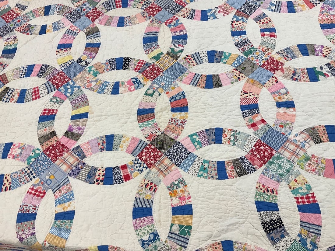 1930's Hand Stitched Double Wedding Ring Quilt: Embroidered date of Dec. 25, 1937. Blue scalloped edge. Some soiling and thinness from use, a few small tears noted. Slightly musty. 70 inches x 82 inches.