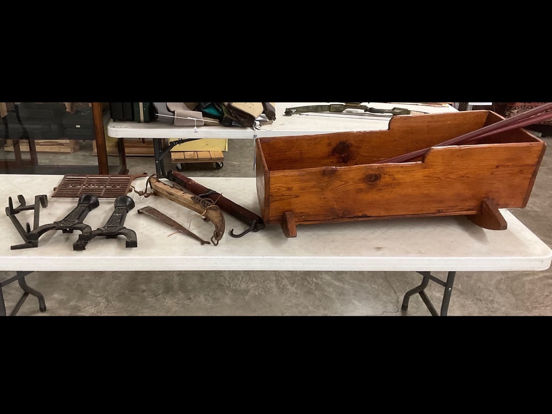 Carved Wood Cradle and Barn Finds: Knotty pine cradle, horse hames, Singer sewing machine pedal, and cast iron andiron fronts with unmatched stands that do not fit. Cradle in overall good condition for age, other pieces in fair conditi