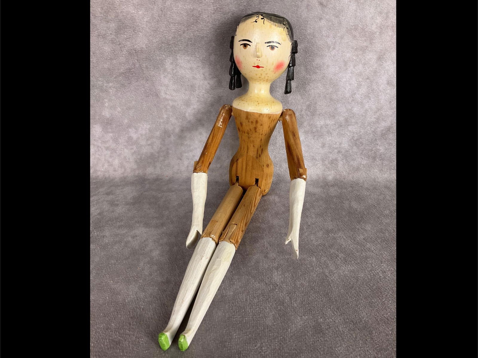 Fred Laughon Jointed Peg Wooden Doll: These dolls were first made in the 1970's. This one is not dated but has the Fred Laughon mark on her back. She has white stockings and green shoes. She has black hair, brown eyes, and rosy cheeks. So