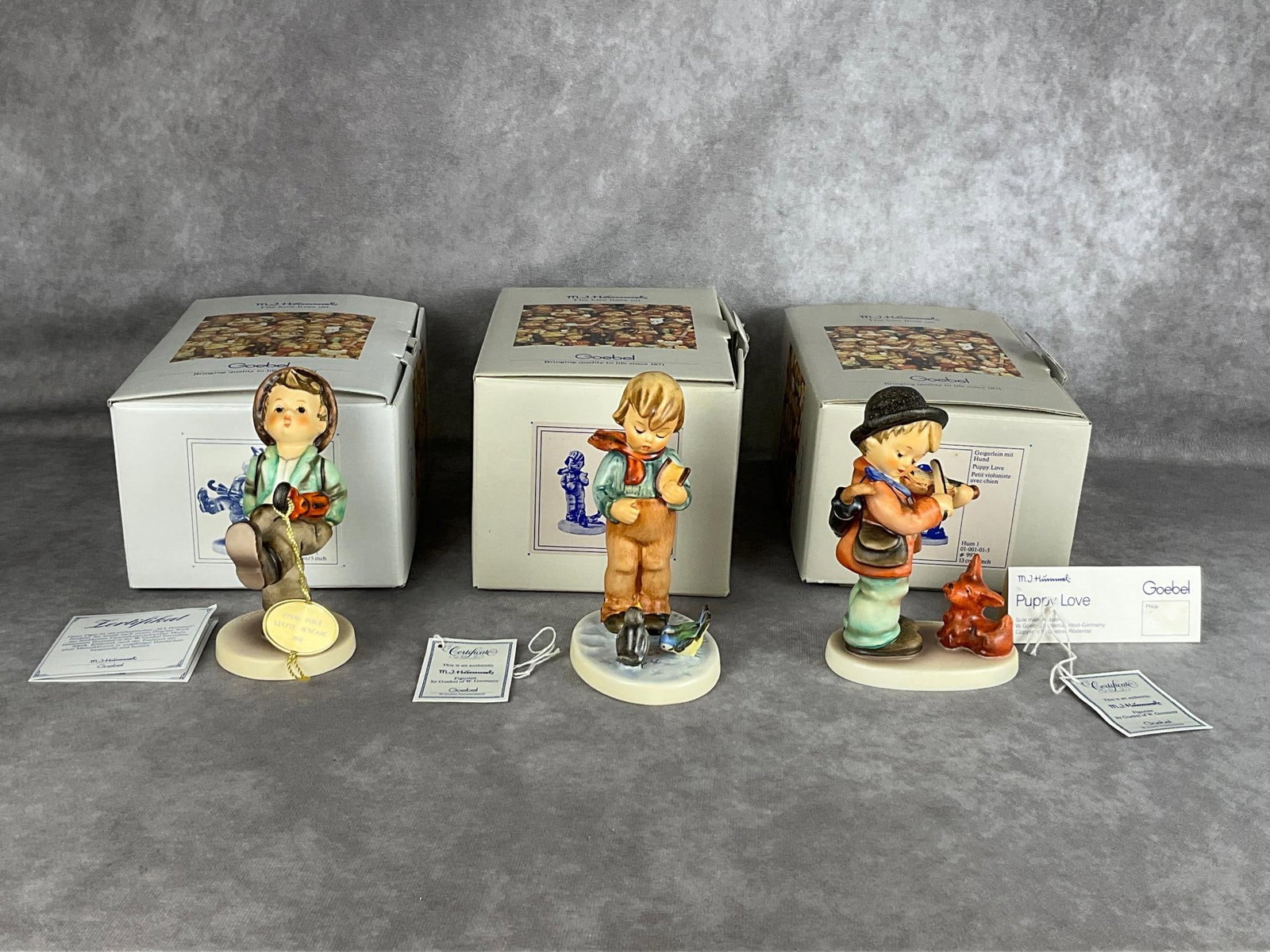 Three Hummel Figurines: All with their boxes. Globe Trotter, Bird Watcher, and Puppy Love. All in good condition. Puppy Love is 5.25 inches tall.