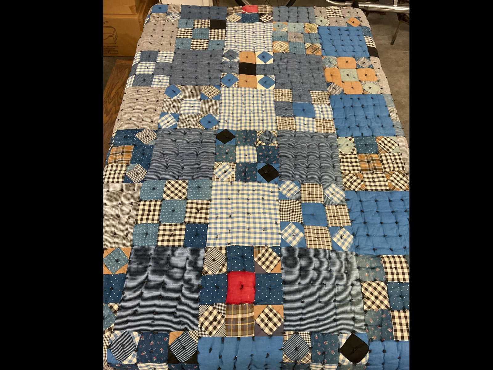 Hand Stitched & Knotted Utility Quilt: Nine patch in blues and blacks. Some fading, a few areas where the fabric is torn and batting shows through. 64 inches wide x 77 inches.