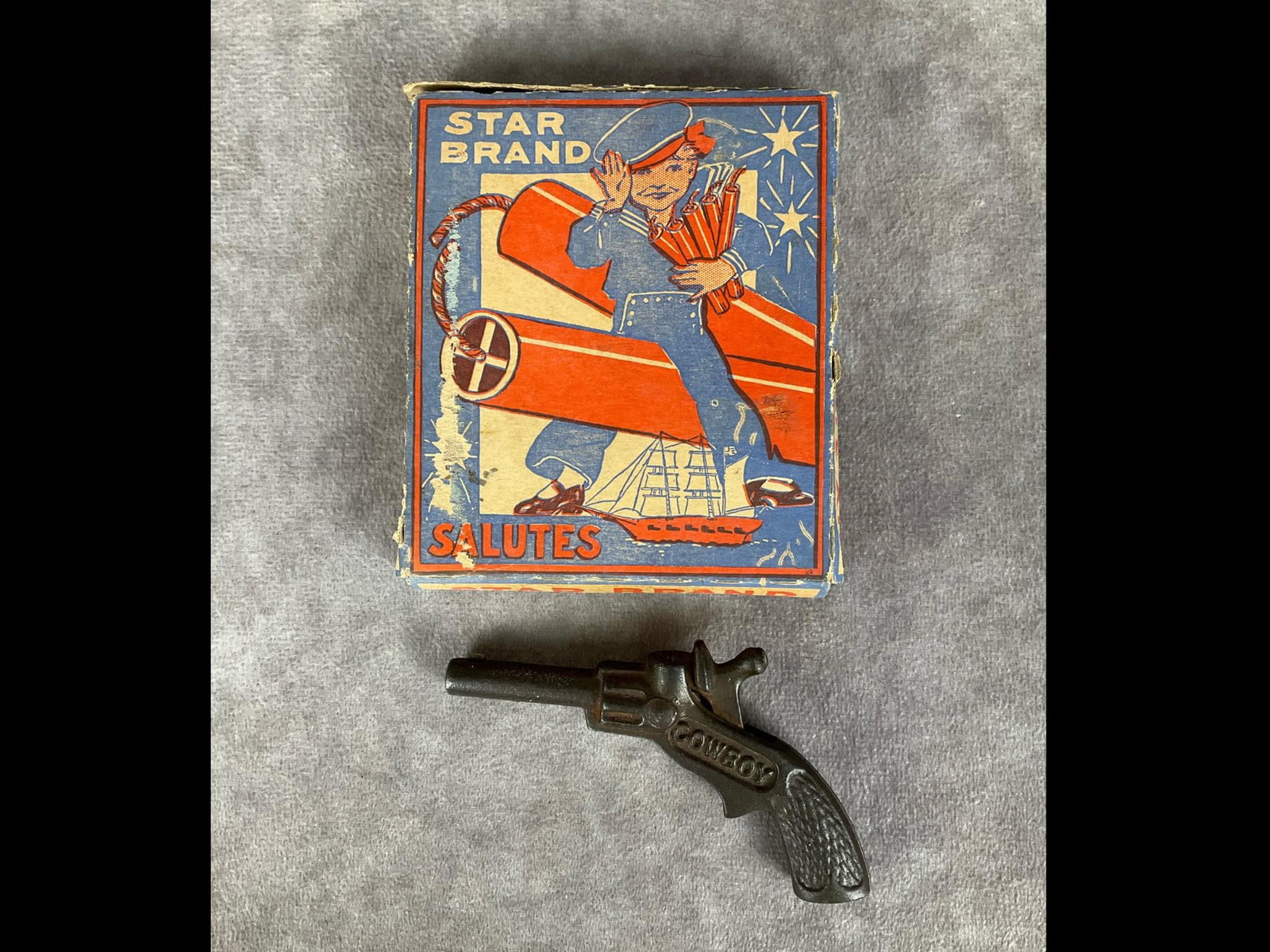 1940's Firecrackers: Star Brand Salutes, manufactured by M. Backes Sons, Inc. of Wallingford, Conn. Complete pack of six in original box with graphic of boy in sailor suit. Upper flap of box has separated and there is som