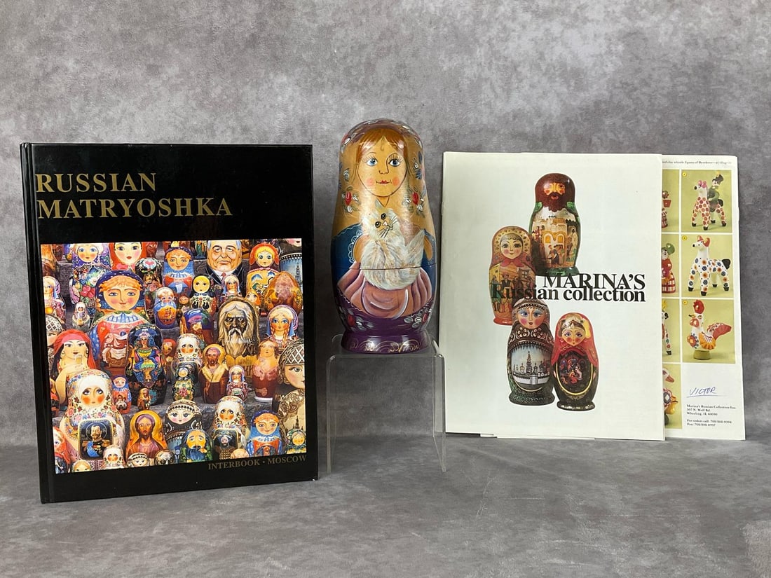 Cat Matryoshka with Book: Handpainted wooden ten piece nesting doll/Matryoshka after the Russian style but sticker on bottom indicates this as having been made in China. Still a quality piece. All dolls depict a girl holding d