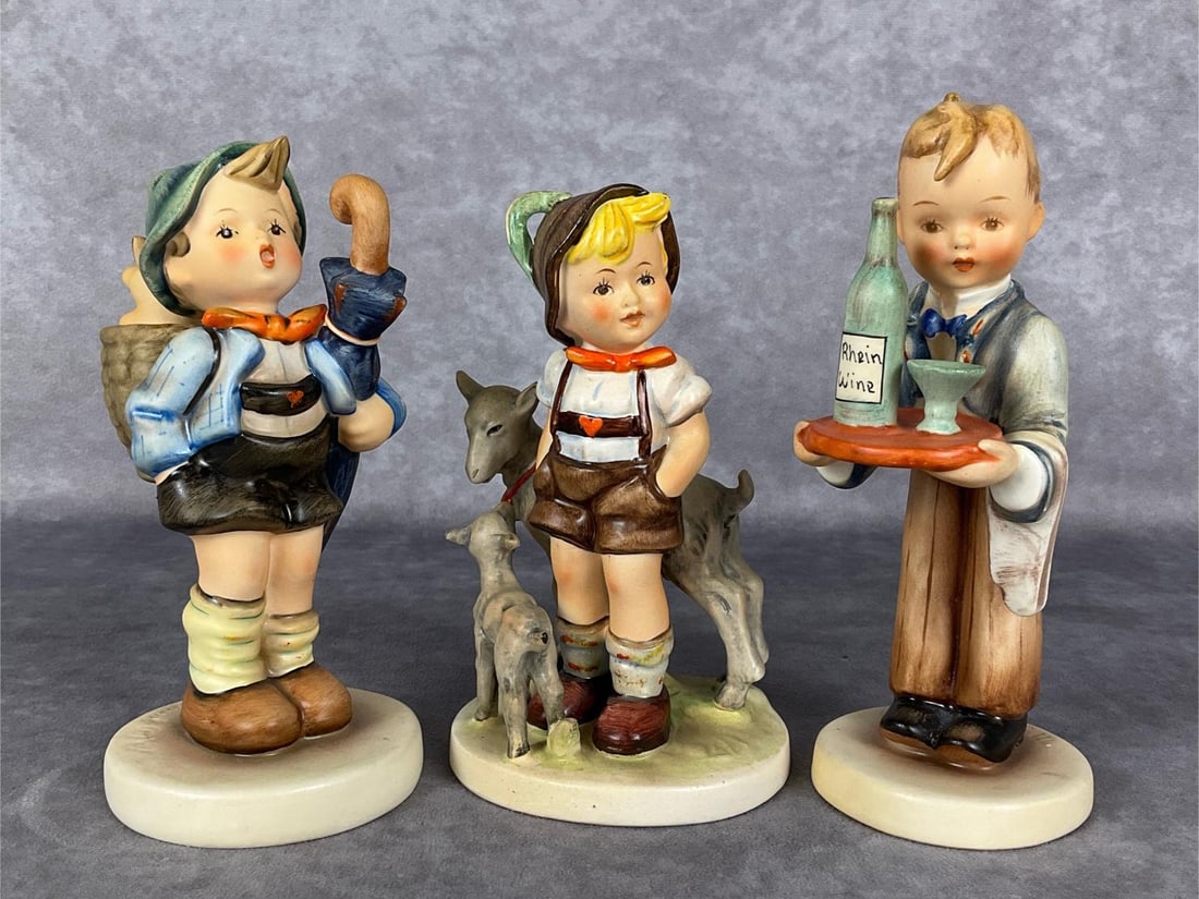 Three TMK 2 Boy Hummels: Home From Market Hum 198, Little Goat Herder Hum 200, and Waiter Hum 154/0 with bottle of Rhein Wine. Tallest 6.25 inches. Good condition.