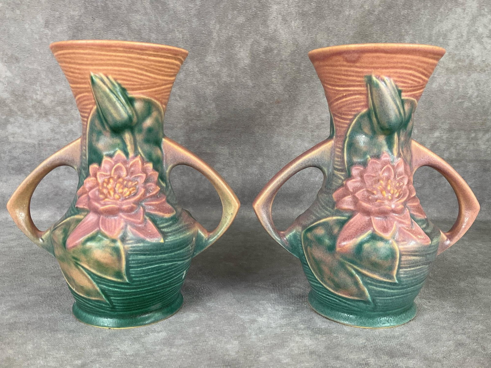 Roseville Pottery Water Lily Vases: Circa 1943. Marked Roseville U.S.A. 73-6. Signs of use to the interiors, tiny chip on bottom edge of one, otherwise good condition. 6.25 inches tall.