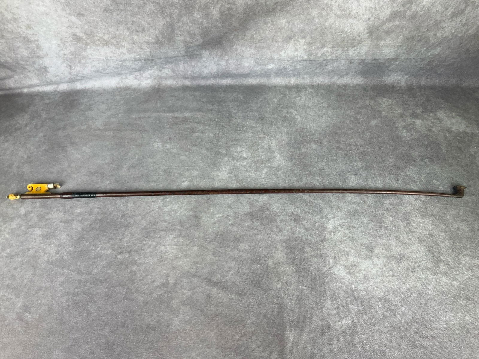 Early 1900's Violin Bow: Possibly German in origin. Simulated snakewood bow with sleigh style frog made of bone with abalone shell slide and eye. Bone end has split and darkened. Hair has been cut. 29.25 inches long.