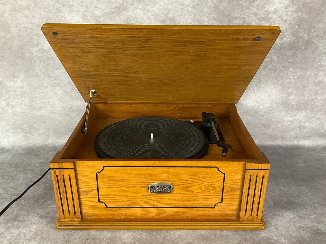Pacconi Turntable: Model TPC-7470 tabletop record player system from the Millennium Series of Thomas Pacconi Classics Inc. Two speed player with built in amplifier and speakers, in wooden case with oak finish. Includes