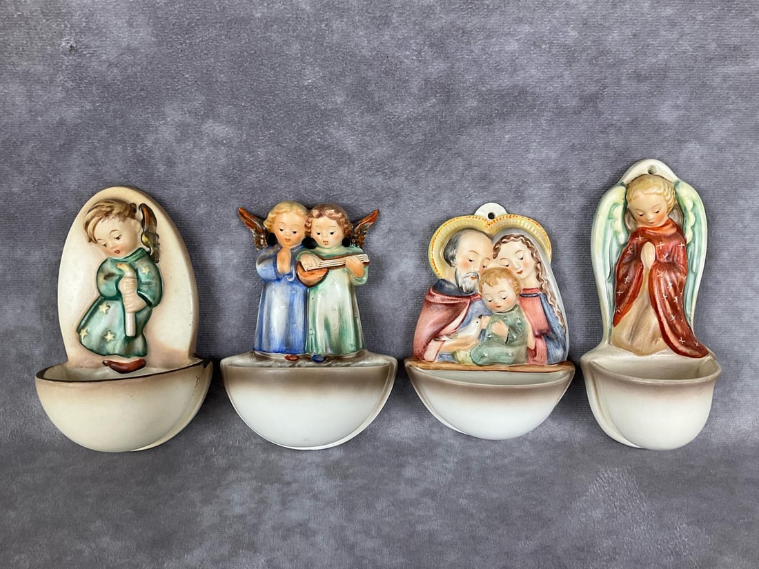 Four TMK 2 Holy Water Fonts: Heavenly Angel Hum 207 in good condition, Angel Duet Hum 146 with minor to moderate crazing, Holy Family Hum 246 with moderate crazing, and Guardian Angel Hum 248/0 with moderate crazing as well. Tall