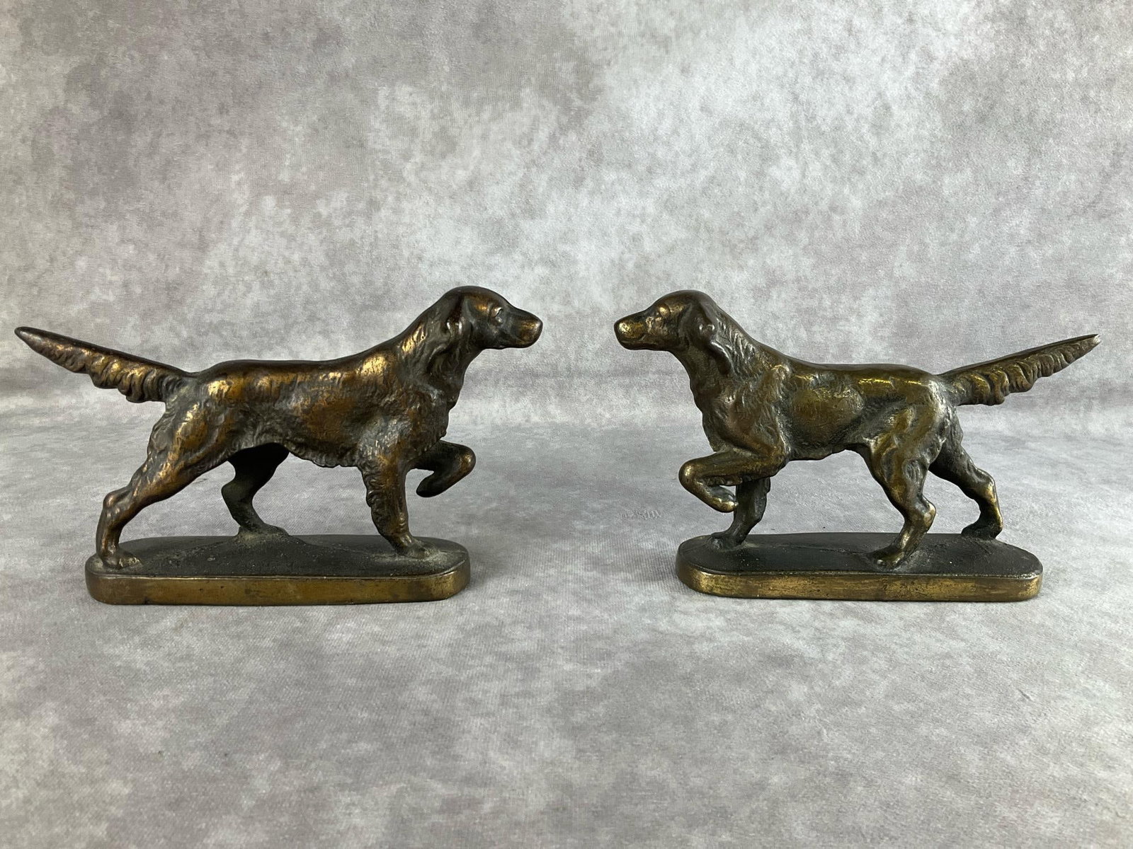 Bronzed Cast Iron Setter Bookends: Unmarked pair of pointer dog bookends. Some wear to patina but overall good condition. 7.5 inches x 5 inches tall.