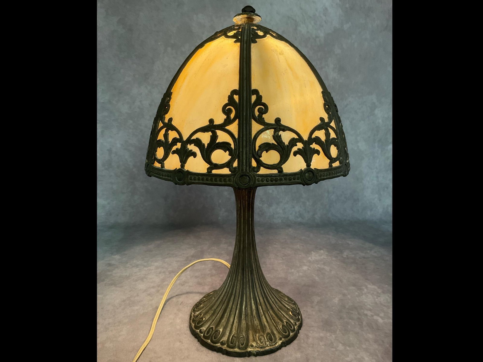 Caramel Slag Glass Boudoir Lamp: Base and frame of spelter with a weighted base. Glass is in good condition. Mushroom dome shade is detached from the cap. Appears to be missing the original finial. It has been glued at some point and