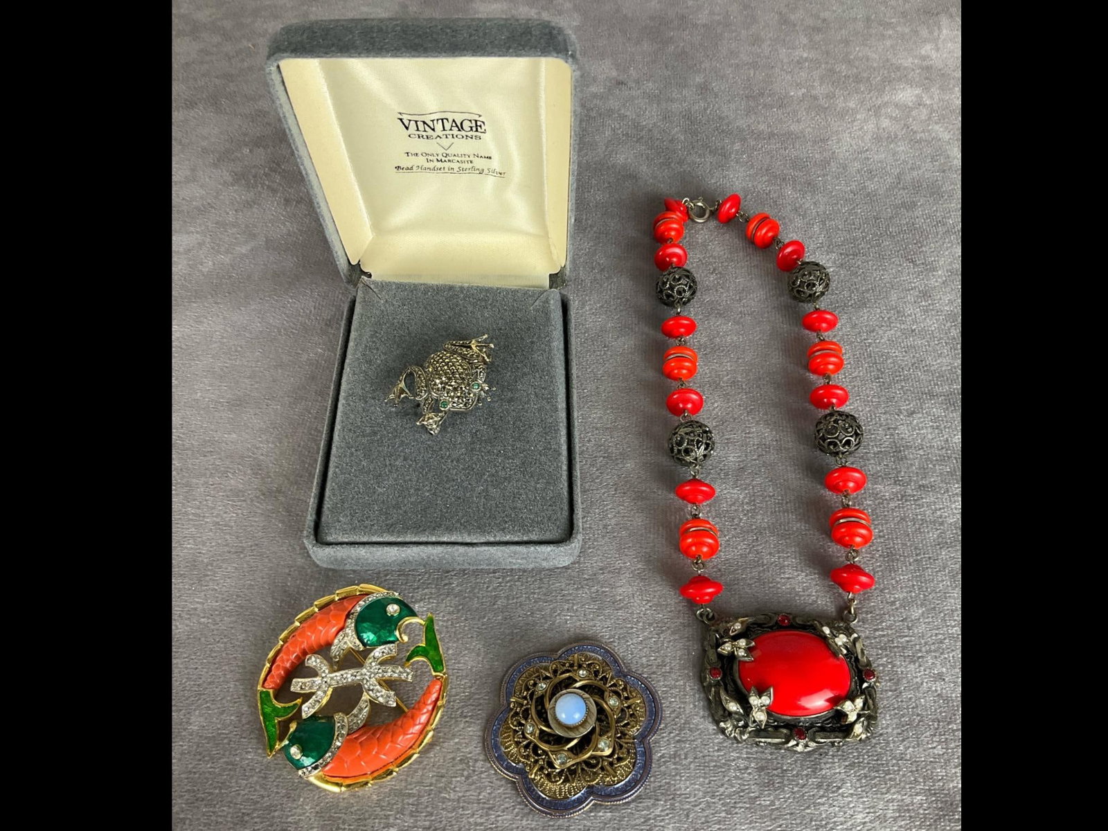 Sterling, Designer Brooches & More: Sterling frog with marcasites by Vintage Creations in presentation box. DeNicola Pisces brooch has two missing and one discolored rhinestones and more. Good condition except where noted. Fishes are 1.