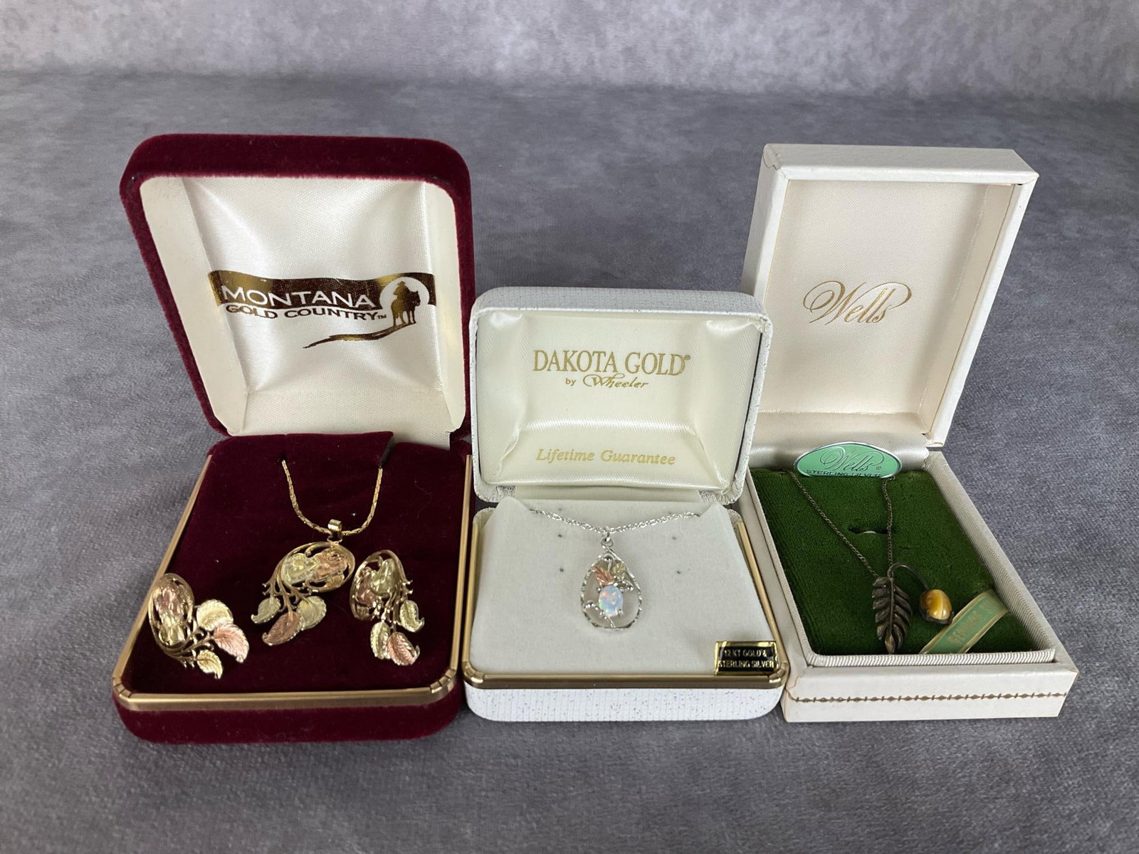 Gold & Sterling Western Jewelry: Dakota Gold by Wheeler; necklace in sterling with 12k gold leaves. On sterling chain in original presentation box. Along with a silver and stone pendant necklace by Wells in original packaging. Pendan