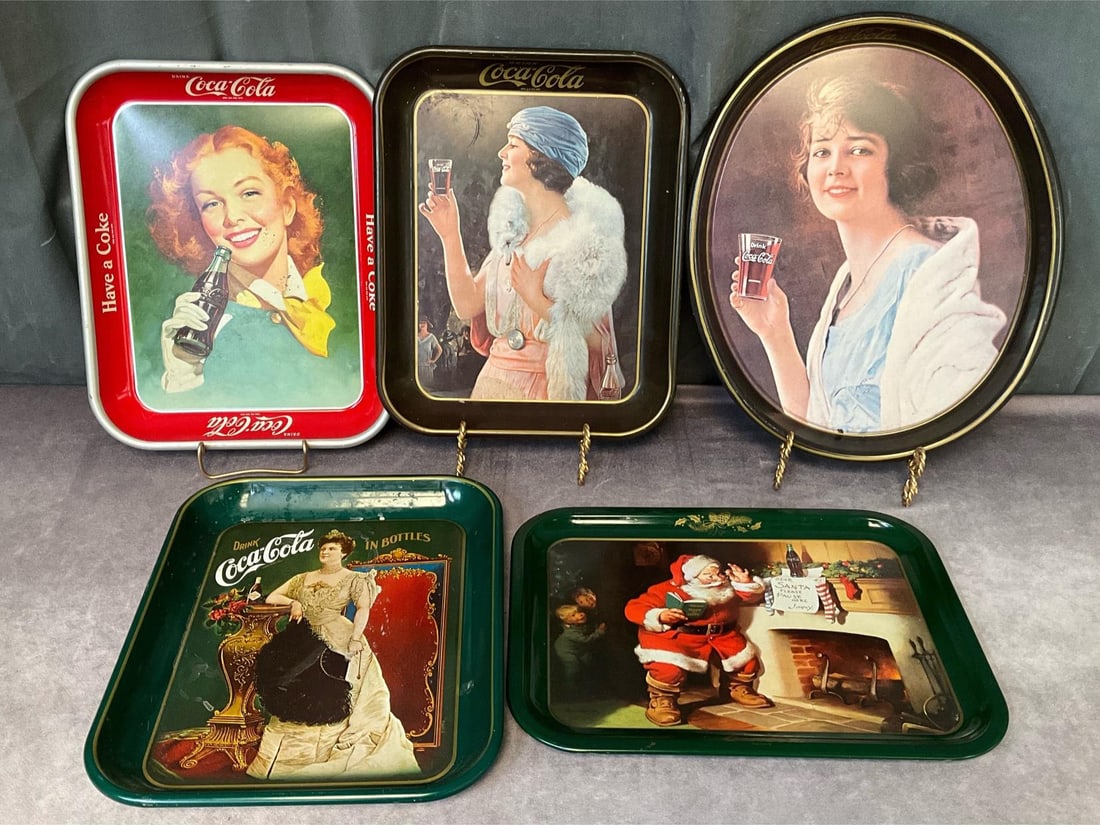 Coca Cola Trays: Five reproduction trays from the 1970s and 80s, oval one is 15 inches tall x 12.25 inches wide. Good condition, but some rust to the back of some. Stands not included.