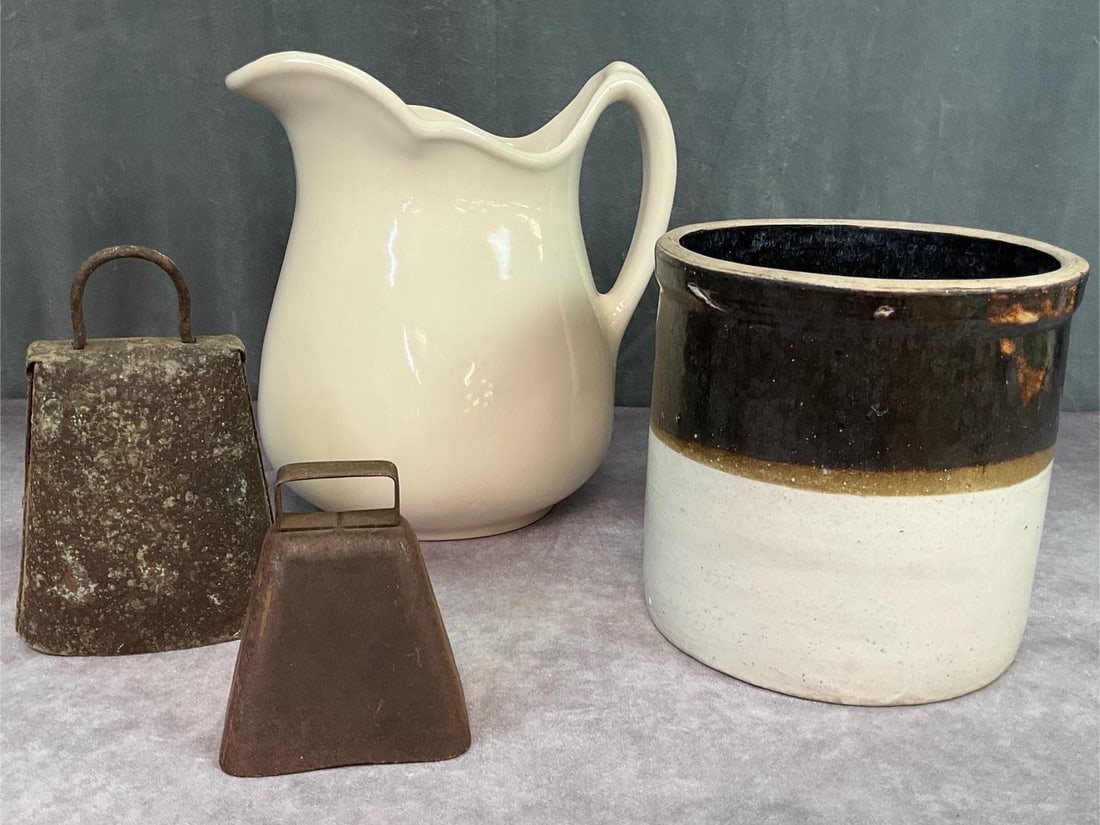 Cast and Copper Cowbells & More: One gallon crock with chip to rim, two cowbells, the small one is missing the clapper, and Sterling China Company pitcher in good condition 10 inches tall x 9.5 inches wide.