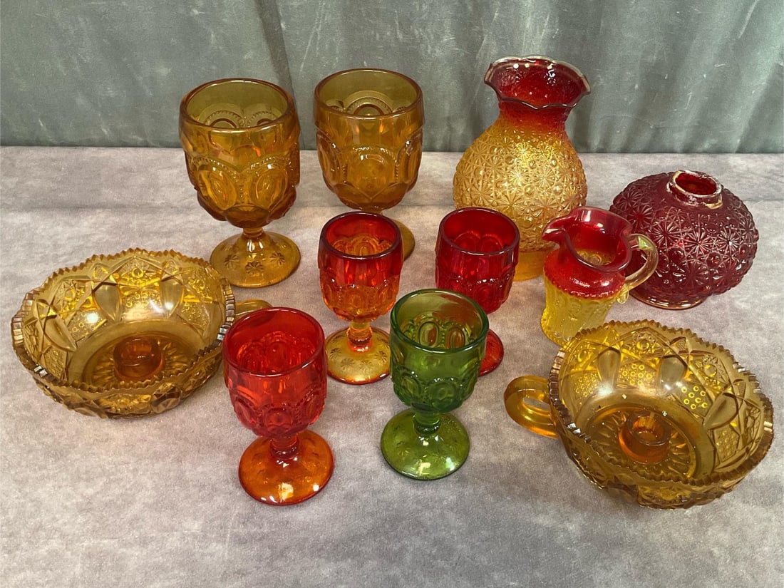 Colorful Pressed Glass: Four L.E. Smith moon and star cordials, 4.5 inches tall. Two L.E. Smith moon and star goblets, 6 inches tall. Two L.E. Smith finger loop nappy candle holders, 5.5 inches in diameter. Kanawha amberina