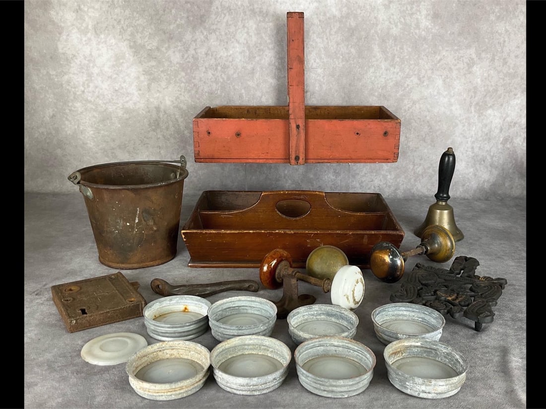 Farmhouse Finds: Red wash paint dovetailed toolbox or cutlery box, zinc jar lids with porcelain inserts, brass hand bell, rusty bucket, wooden cutlery tray, porcelain doorknobs, cast iron trivet, and more. All show we