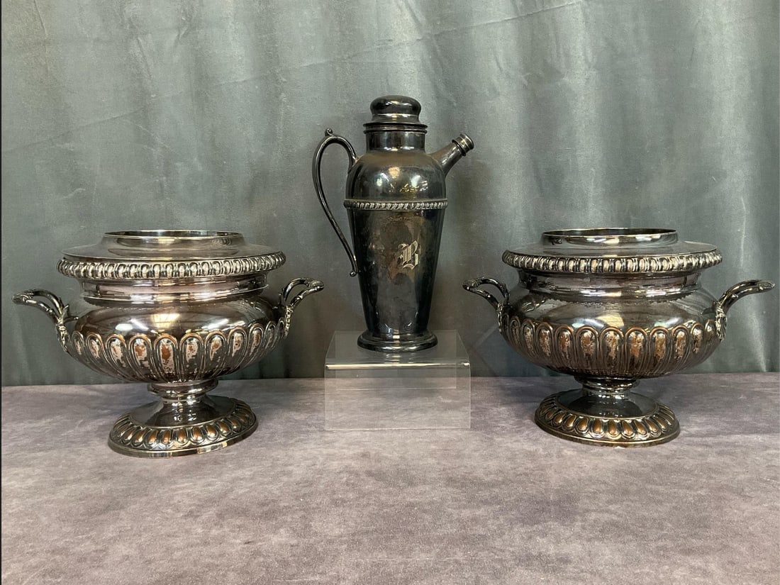 Hollywood Regency Cocktail Hour Pieces: 1920s Crescent silver plate cocktail shaker, 11 inches tall x 7 inches wide, and two heavy unmarked wine or champagne coolers. All show signs of wear.