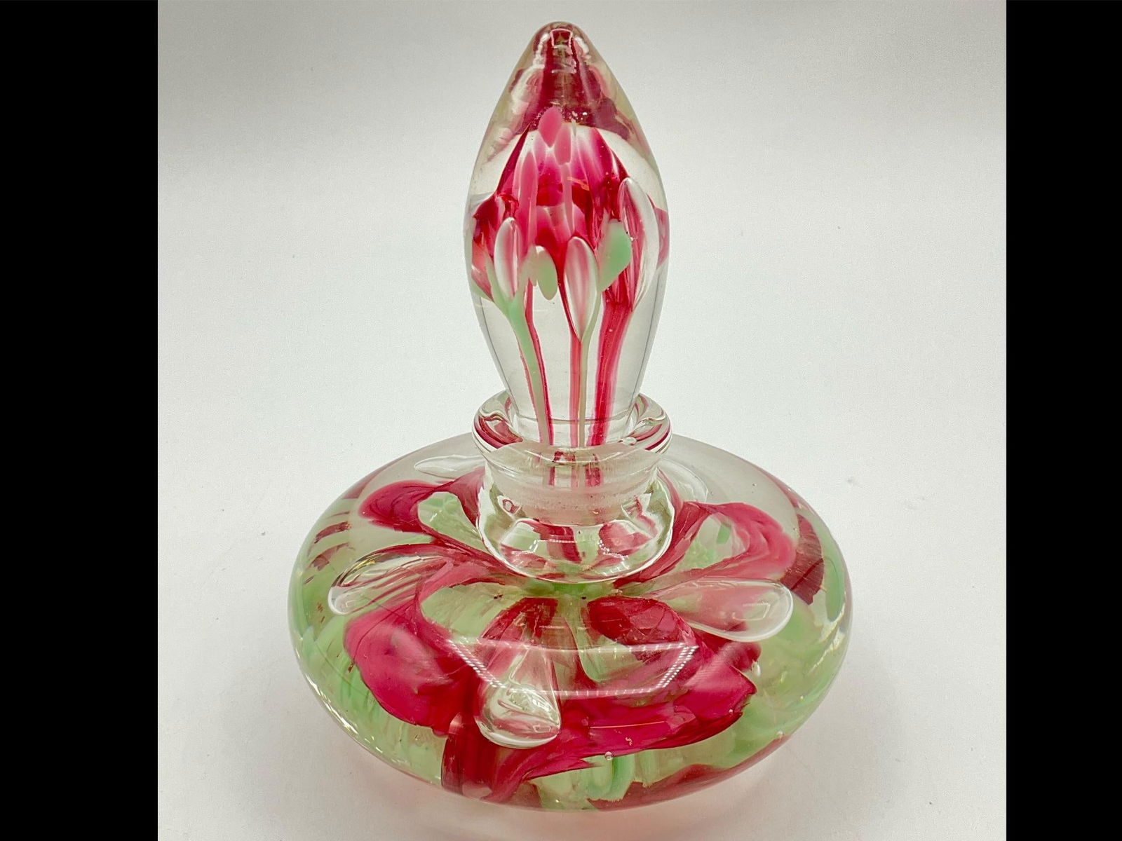 Paperweight Art Glass Perfume Bottle: Clear, pink, and mint green. Unsigned but in a similar style to pieces by Joe St. Clair. Good condition. 4 inches wide x 5.25 inches tall.