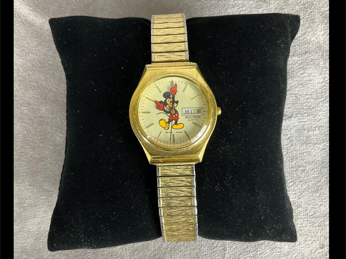 Accutron Quartz Mickey Mouse Wristwatch: Model P2. Rough edges to crystal. Wear and scratches to gold tone setting. Speidel band is still in decent condition, some loss of gold tone.