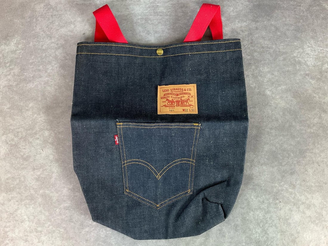 Levi Strauss Denim Backpack: 1970s style 501 blue jean tote bag with red canvas backpack stripes. Button closure, 16 inches tall x 14 inches wide. Good condition, only a couple small spots on back.