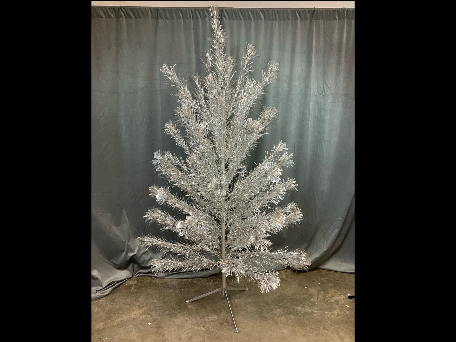 Aluminum Christmas Tree: 1960s seven foot tall pom pom tinsel Christmas tree. All branches are present, approximately 75 branches with brown paper sleeves. Damage to one branch. Good condition.