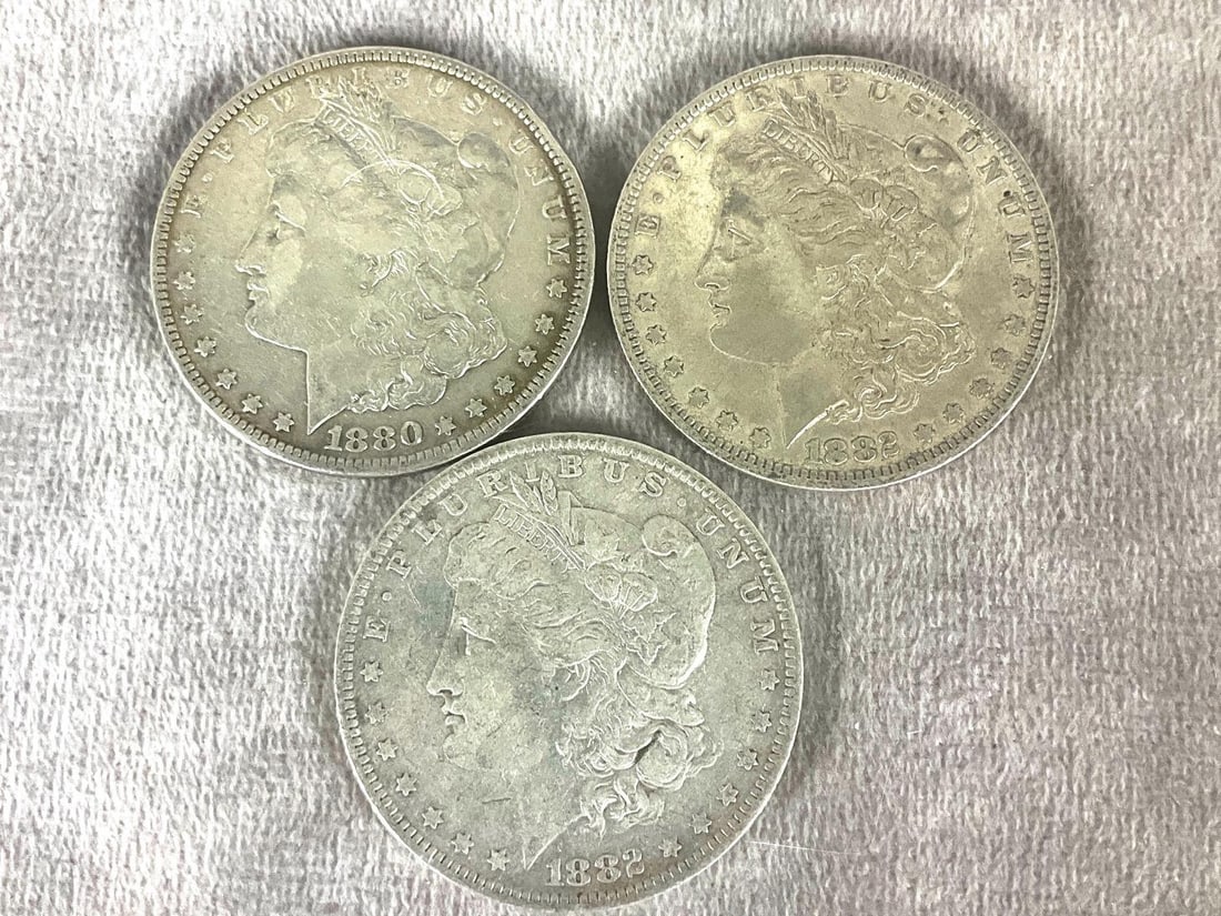 Three Silver Morgan Dollars: All are circulated. Philadelphia mint. One is 1880, the other two are 1882.