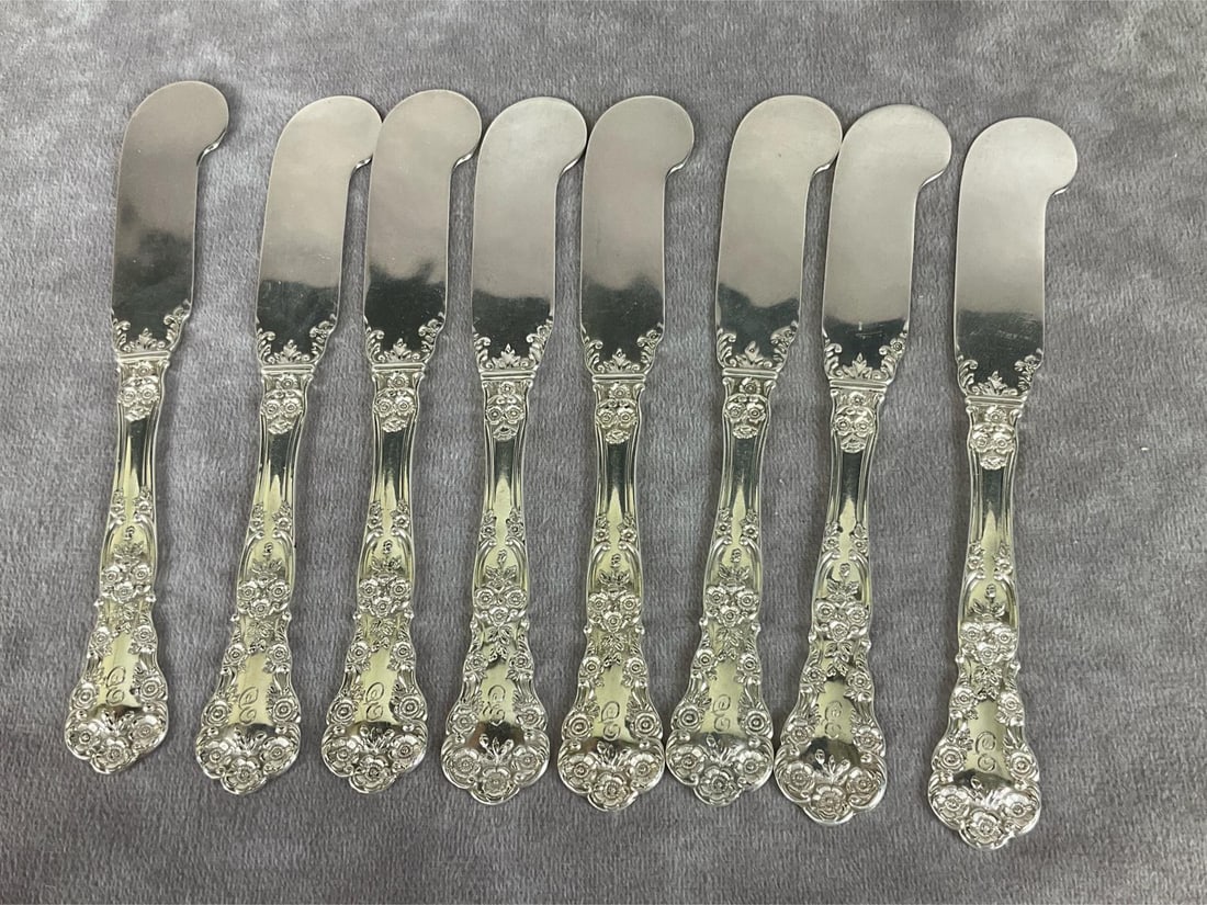 Gorham Buttercup Sterling Flat Handle Butter Knives: Group of eight. Marked sterling. Measures 6 inches long. Light scratches and tarnishing. Monogrammed with E. 6.36 ozt silver.