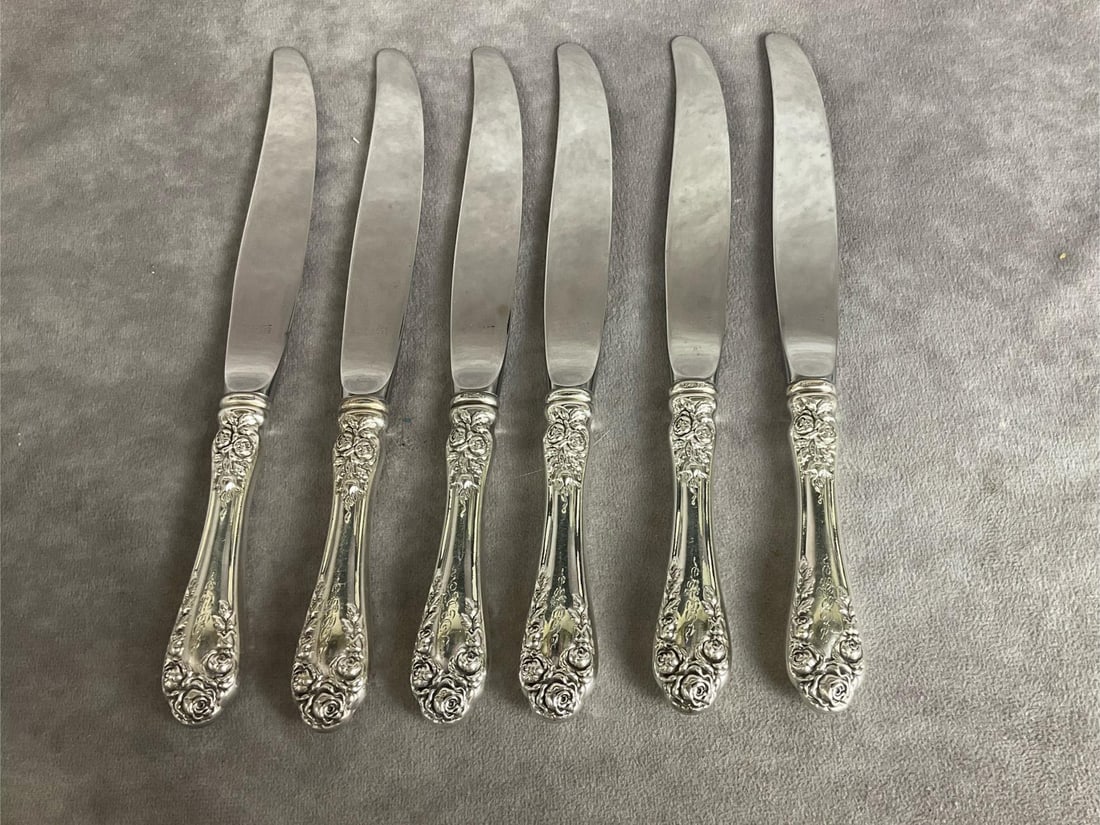 Wallace Sterling Rose Dinner Knives: Group of six. Handles are marked Sterling, blades are marked stainless . Measures 8.5 inches long. Light scratches and tarnishing. Monogrammed.