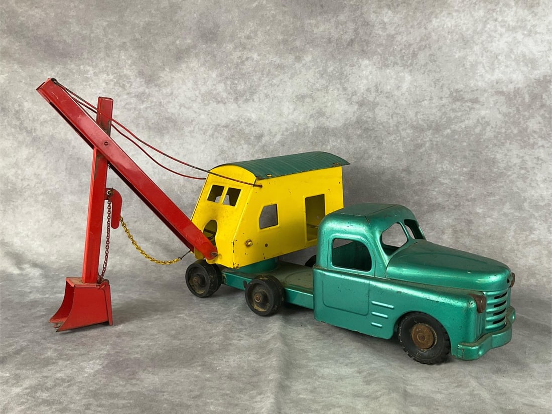 Structo Toys Shovel Truck: Circa 1950. Pressed steel, measures 27 inches with the shovel arm at rest. Overall good condition with rust, and paint loss. Very vibrant for the age.