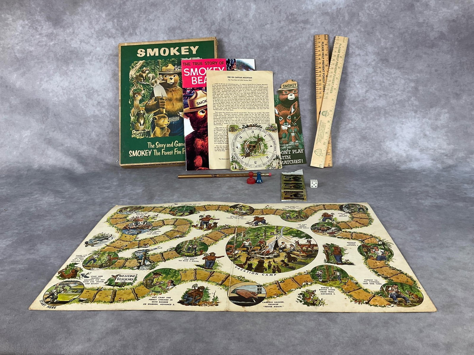 Smokey the Bear Board Game & Memorabilia: Smokey the Bear board game with spinner, board, one playing piece and box. Includes Smokey the Bear comic book, three stickers, two rulers, and a pencil. In good condition, with some drawing on the in