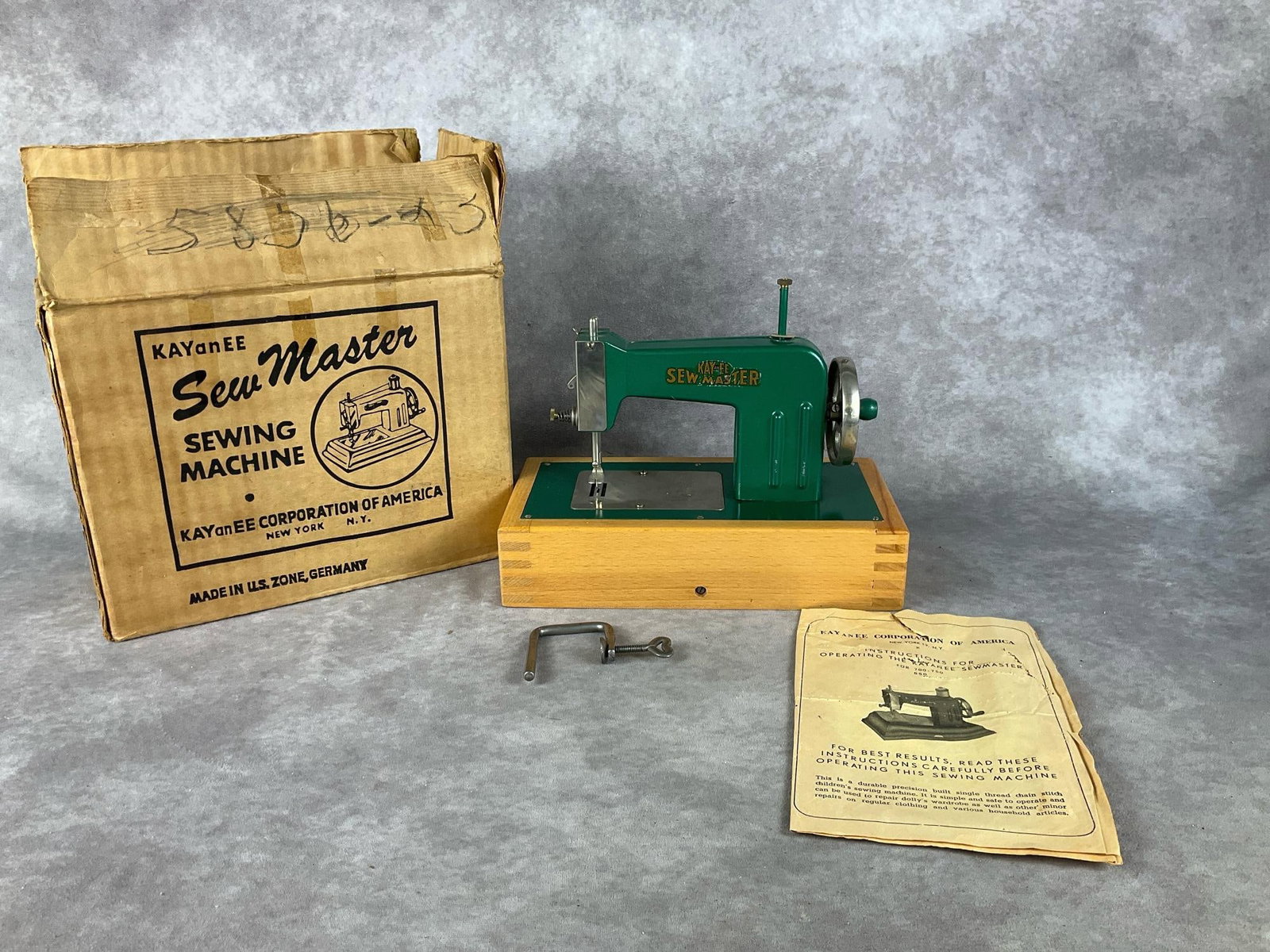 Kay and EE Sewmaster Sewing Machine: Child's sewing machine, circa 1950. Includes box and instructions. Some scratches and rust, but otherwise good condition. Box has visible wear and damage. Sewing machine measures 10 inches wide by 8 i