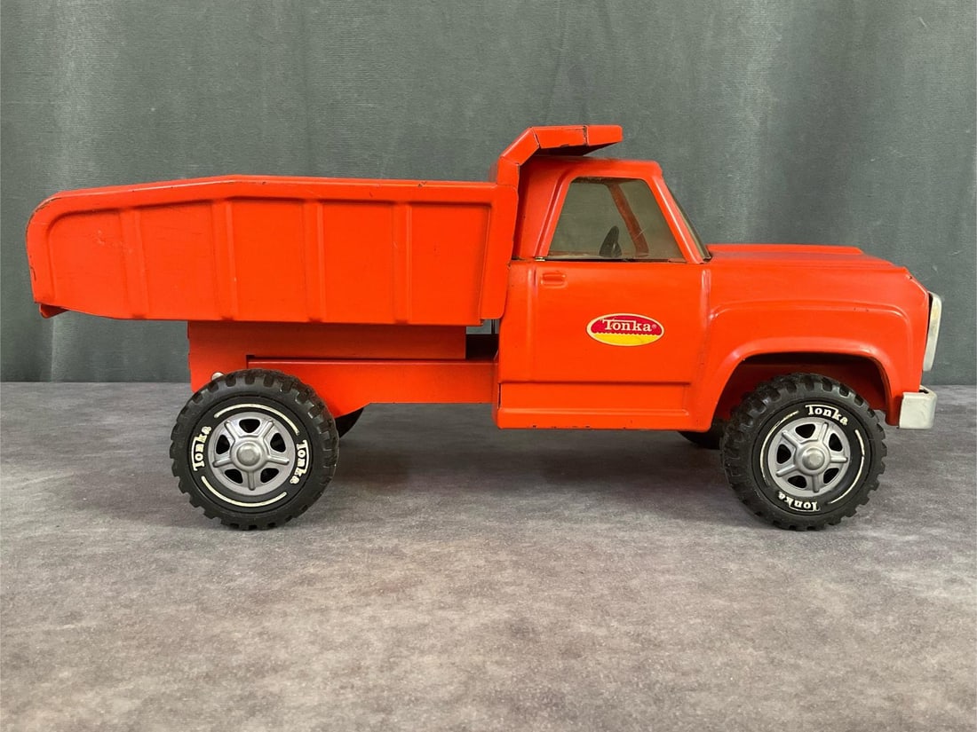 Tonka Dump Truck: Circa 1970 pressed steel truck. Plastic wheels, metal bumper and grill. Missing one Tonka sticker, wear to edges and scratches. 13.75 inches wide x 6.25x 5.75 inches tall. Fair to good condition.