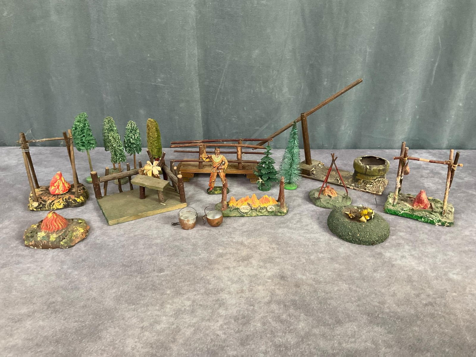Elastolin & Other Campfire Accessories: 1930s to 1950s German campfire and other diorama accessories. Lineol campfire with red metal stakes, other campfires marked Germany with real sticks as stakes. A well, bridge, and picnic area all mark