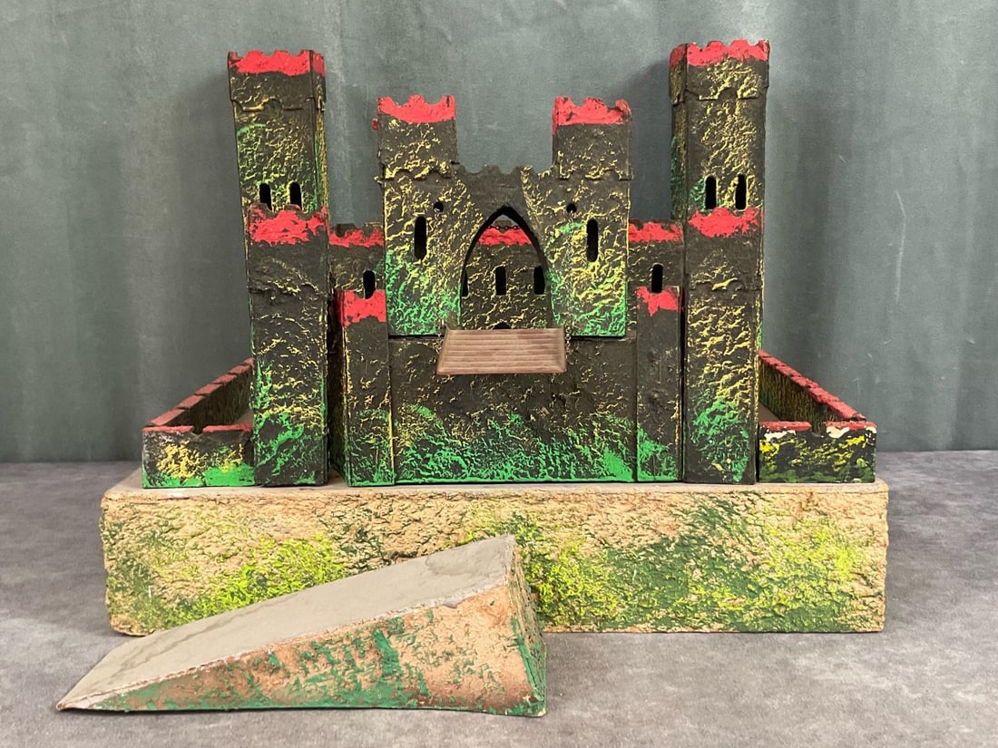 Tri-Ang England Toy Fort: Wooden base with cardboard and paper mache fort. Working drawbridge. Paint loss and scuffs in a few spots, water damage to ramp. Base is 15 inches wide x 2.75 x 12.75 inches long.