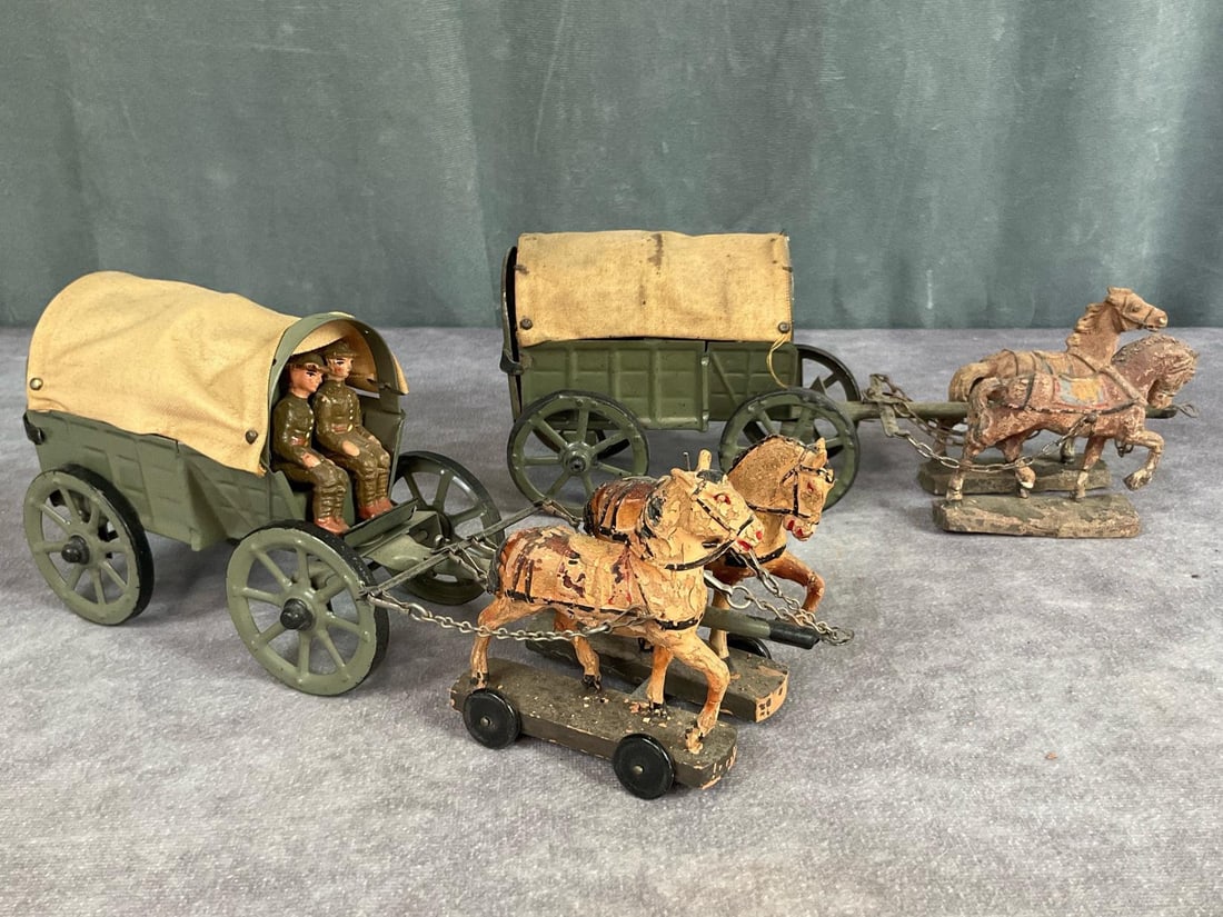 Elastolin Covered Supply Wagons With Horses: One original 1920s tin wagon with canvas cover and hinged door on back. Marked Germany on bottom. One pin is missing to tack down a corner of cover and stains to canvas. Other wagon appears more moder